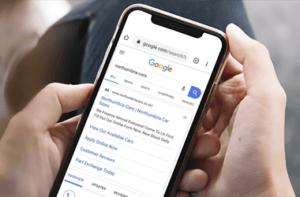 anúncios: mãos segurando celular com SERP Google