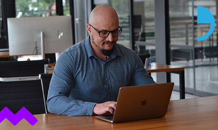 Imagem de um homem com seu notebook, sentado a mesa