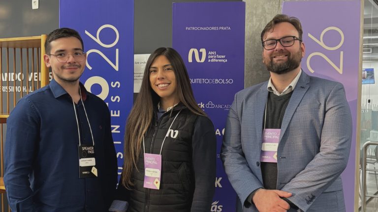 Equipe da AN1 diante do painel de patrocinadores prata do Tijolo Business 2026, em Porto Alegre